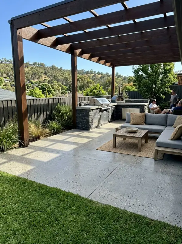 Honed concrete alfresco under a timber pergola with the hills beyond, Burnside