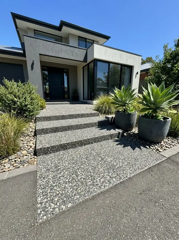 Charcoal exposed aggregate entry path with wide steps at a rendered home, Burnside