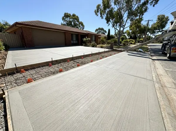 A driveway ready to pour, with steel mesh on chairs over a compacted base inside formwork set to a fall