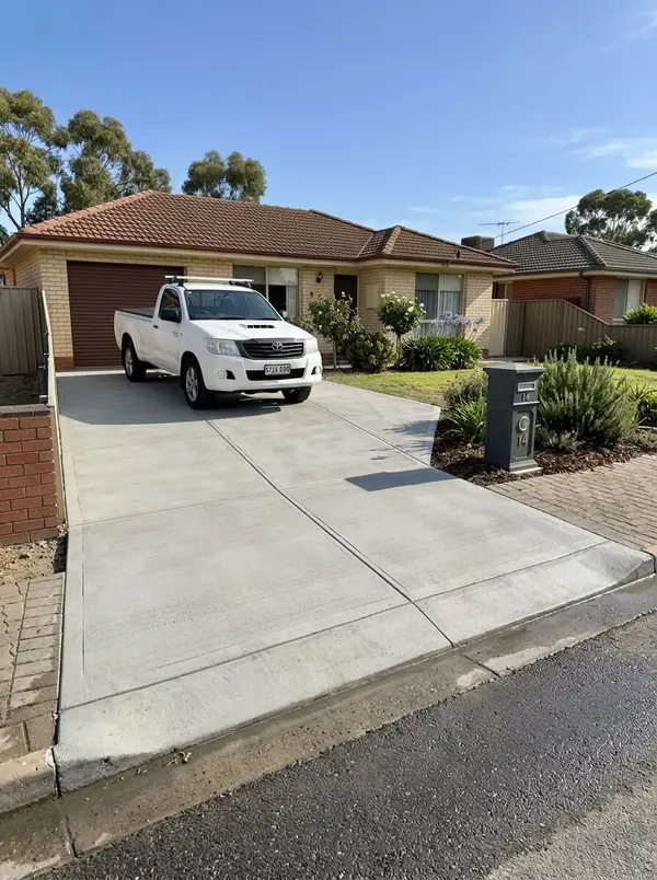New broom-finished concrete driveway and crossover at a cream brick home, Salisbury