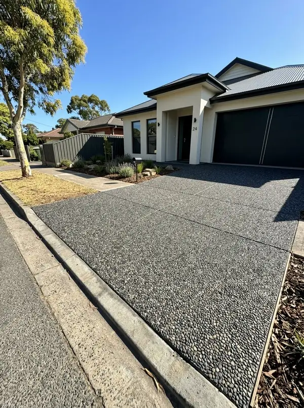 Charcoal exposed aggregate double driveway at a modern rendered home, Glenelg