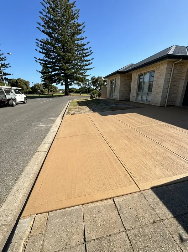 Coloured concrete driveway in a sandstone tone at a limestone-clad home, Henley Beach