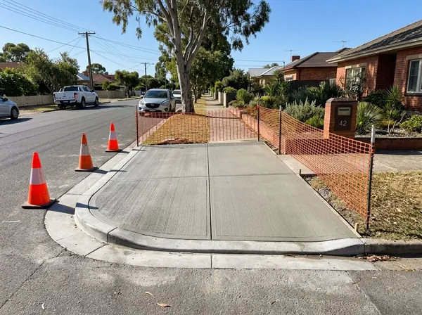 A newly poured concrete crossover fenced off at the kerb