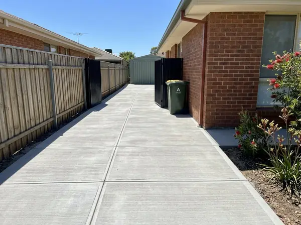 Narrow concrete side access path and carport apron