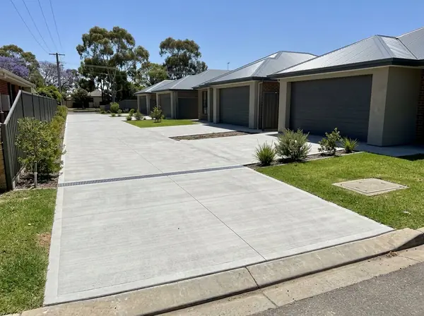 Long shared concrete driveway serving a row of unit homes