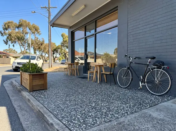 Charcoal exposed aggregate cafe frontage with outdoor tables