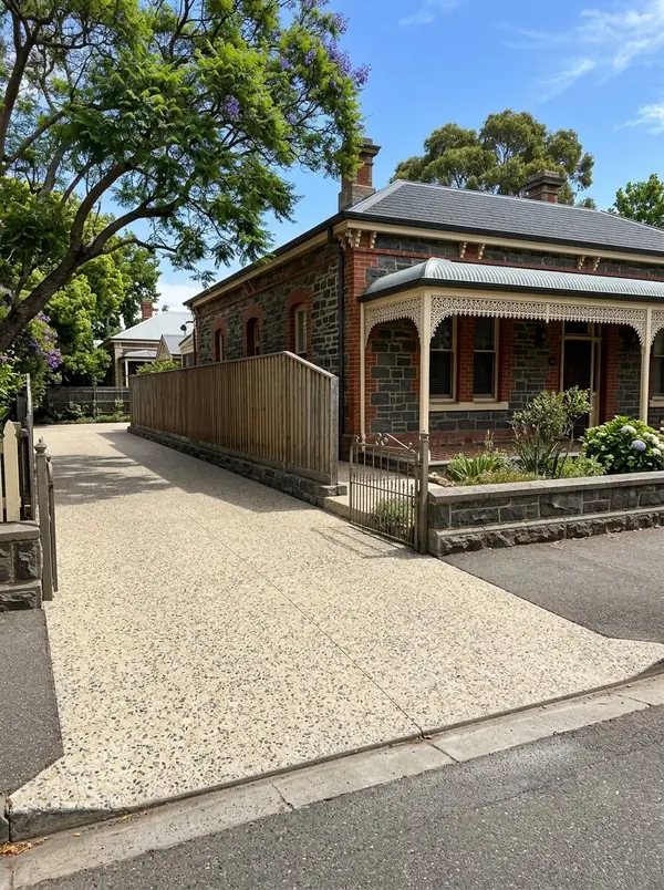 Cream sandstone exposed aggregate driveway beside a bluestone villa, Unley