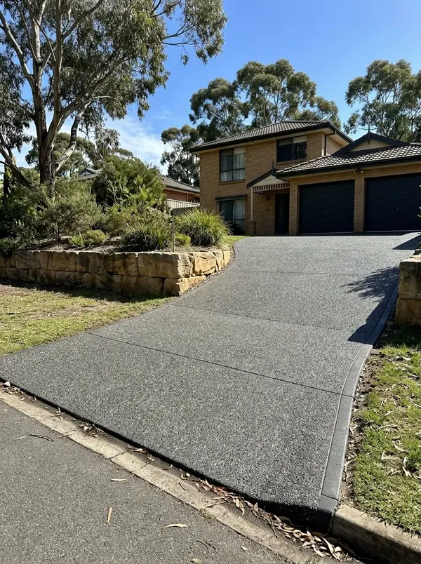 Charcoal exposed aggregate driveway on a sloping block at a two-storey brick veneer home, Golden Grove