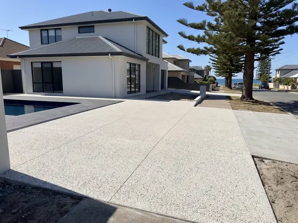 A new coastal white exposed aggregate driveway at a modern two-storey home a street back from the beach in Henley Beach