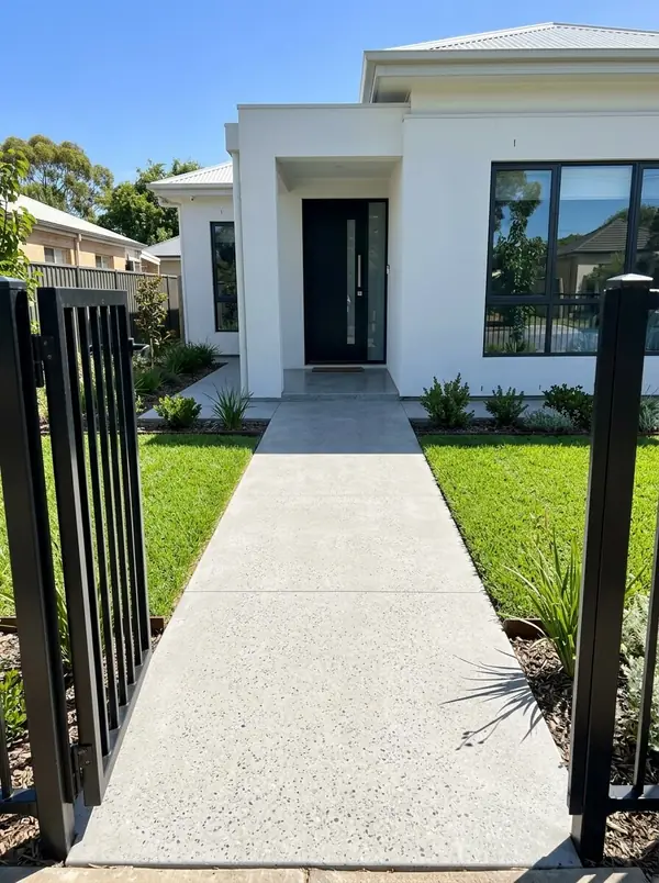 Honed concrete front path and porch at a white rendered home, Norwood