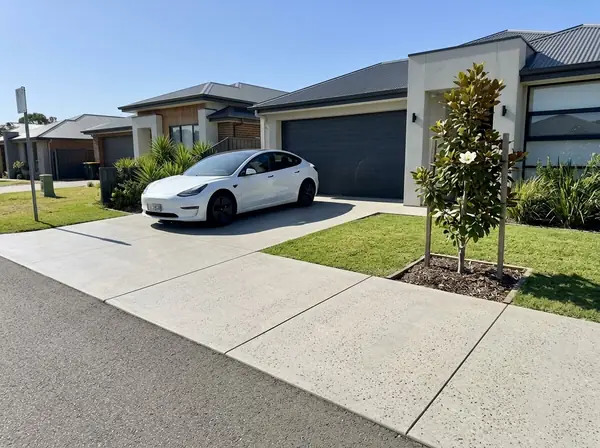 Flat honed concrete driveway to a modern home