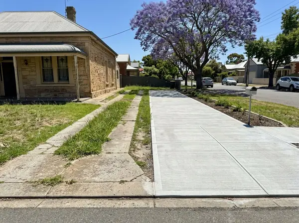 An old narrow strip driveway with grass up the middle beside a villa, next to a neighbour's new full-width driveway, Prospect