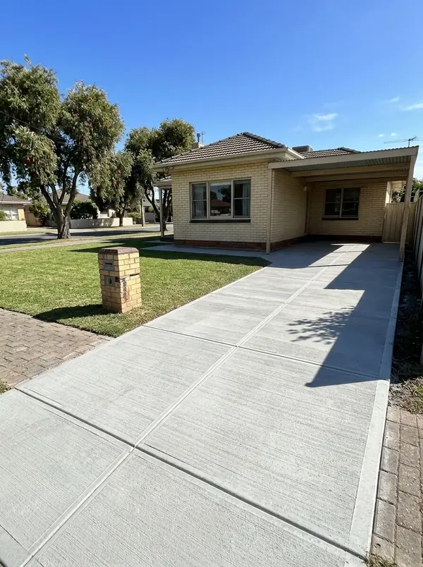 New broom-finished driveway and carport apron at a 1950s cream brick home, Nailsworth