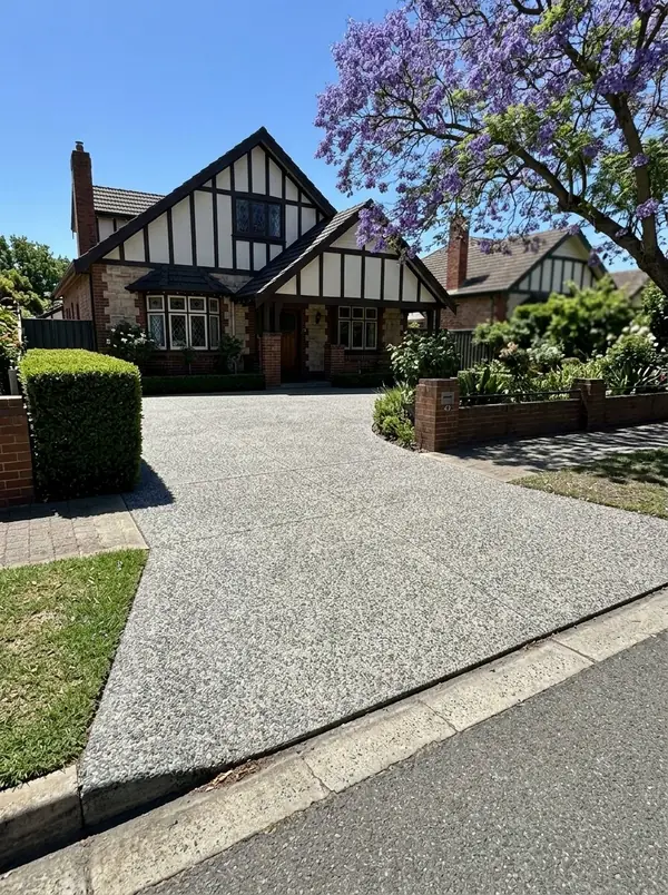 Natural grey exposed aggregate driveway at a 1930s Tudor-style home, Broadview