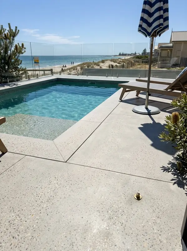 Pale honed concrete pool deck beside a plunge pool at a beach house, Henley Beach