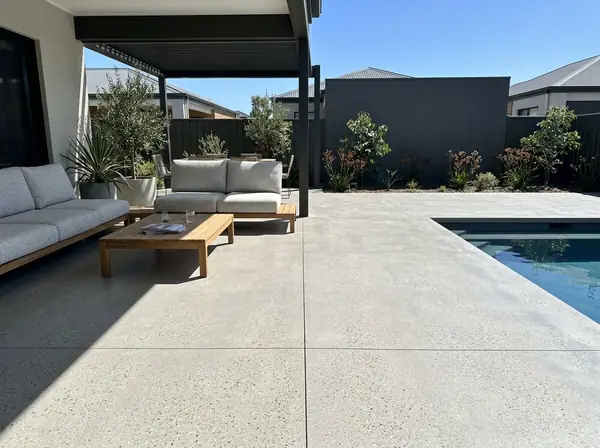 Honed concrete pool deck flowing into a covered alfresco