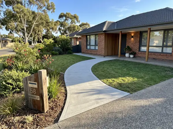 New concrete front path curving from the driveway to the porch of an Adelaide home