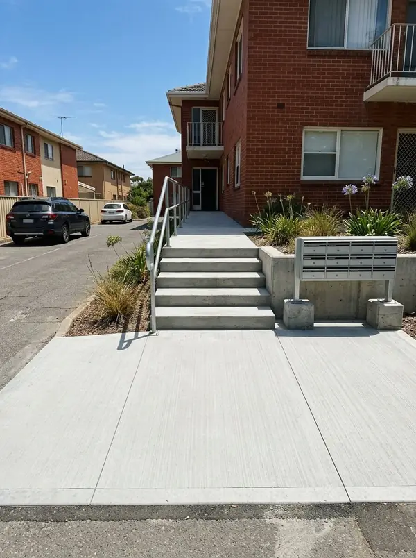 Wide concrete footpath and stairs with a handrail at a block of units, Glenelg