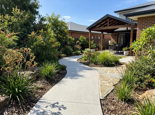 Honed concrete garden walkway winding through a native garden