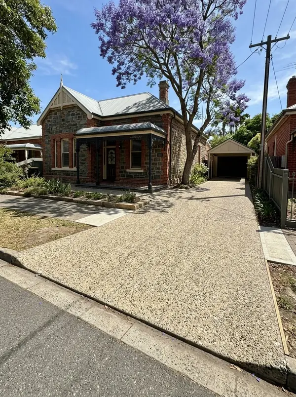 Cream exposed aggregate driveway beside a bluestone and red brick villa, Unley